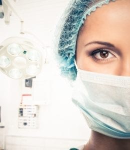 woman doctor in cap and face mask in surgery room