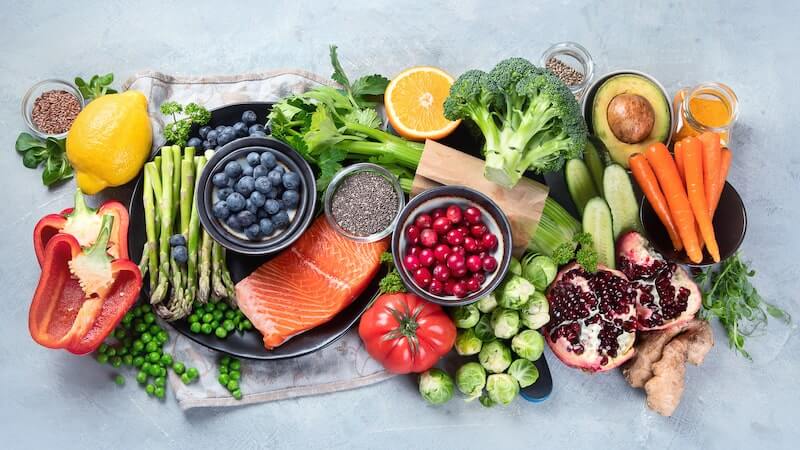 A beautiful array of healthy foods, including fruits, vegetables, and fish